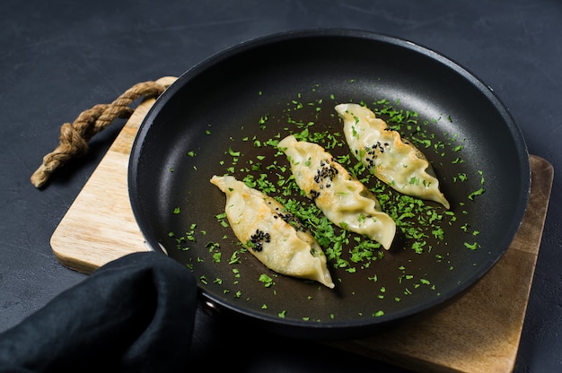 Fried Korean dumplings in a frying pan.  