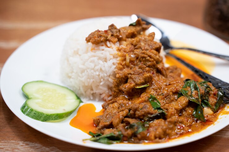炊いたご飯の上にカレーペーストで揚げたラム肉