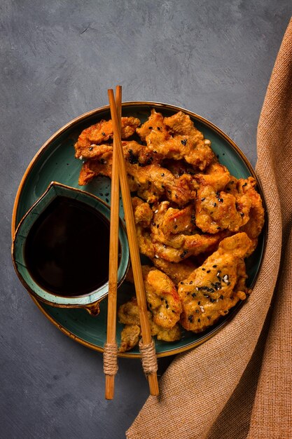 Fried meat in batter deepfried with sesame seeds and soy sauce on a gray table there are no people