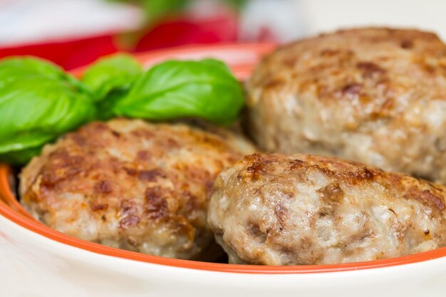 Fried meat cutlets with basil leaves and pepper