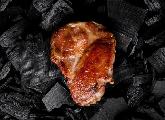 Photo fried meat steak on a black background of charcoal cooked juicy beef steak on the coals