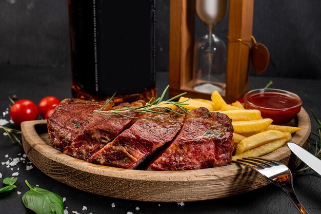 木製の背景にフライド ポテトとケチャップを添えた揚げ肉ステーキ