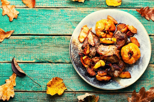 Fried meat with autumn quince on the plate.Space for text