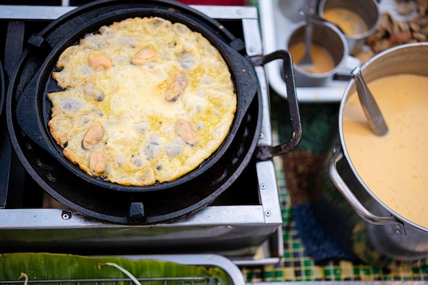 Fried mussel pancakes Cooking mussel fried in egg batter on iron pan