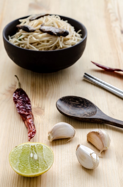 Fried noodle in black bowl on wooden table, Thai street food