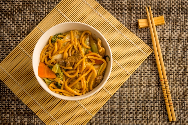 写真 焼きそば。牛肉、鶏肉、野菜を白いボウルに入れた焼きそば。