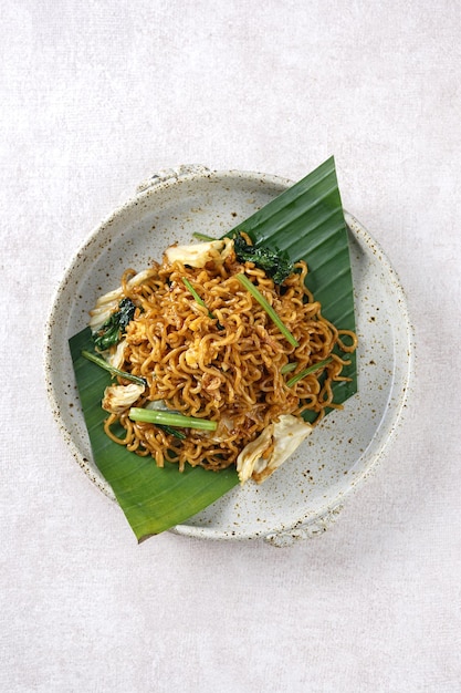 Fried noodles served with spices and vegetables on a plate