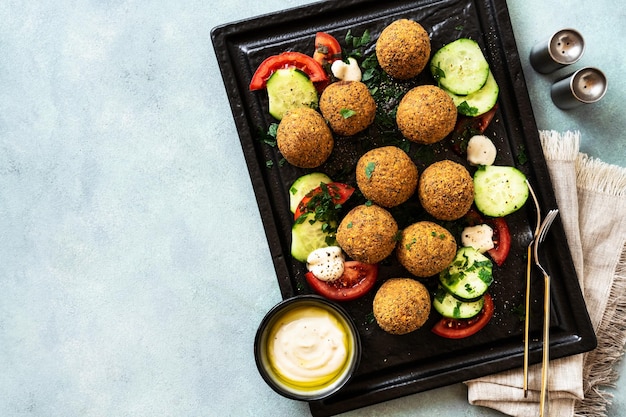 Foto falafel fritti in olio con insalata di pomodori cetrioli e yogurt con olio d'oliva