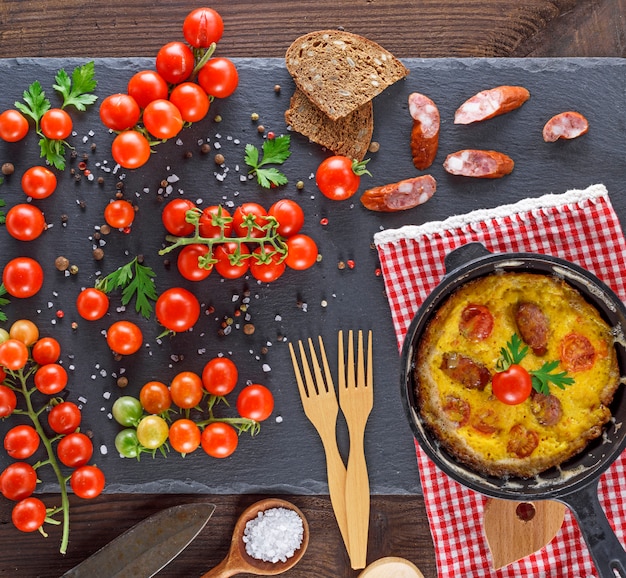 Fried omelette from chicken eggs with red cherry tomatoes 