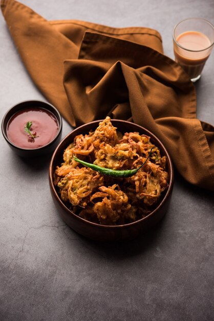 揚げタマネギのパコラまたはPyajPakodaは、クリスピーカンダバジ/バジ/バジとも呼ばれ、梅雨の時期に人気のインドのティータイムスナックです。トマトケチャップ添え