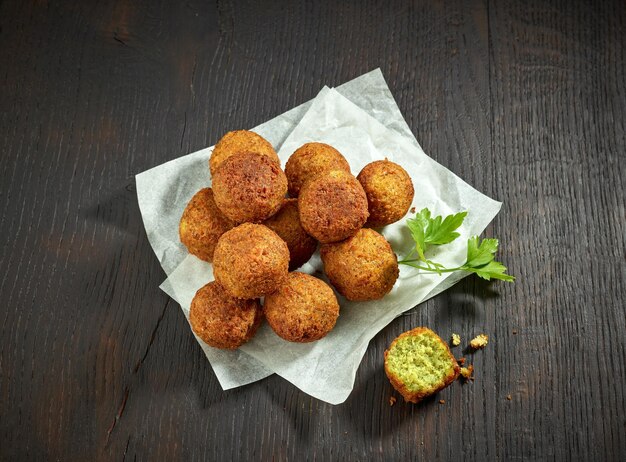 Fried organic falafel balls on black wooden table halafel top view