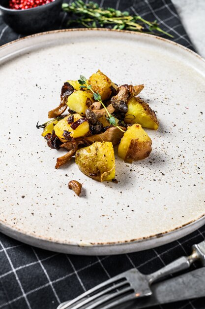 Fried oyster mushrooms with potatoes and thyme. Gray background. Top view