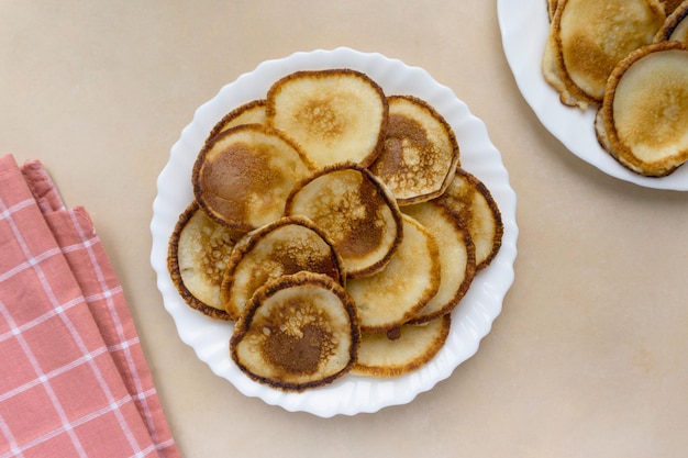 Fried pancakes on beige background, top view