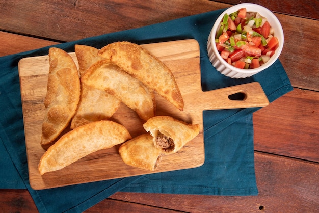 Photo fried pastries pastel frito brasileiro on wooden table pastel de carne