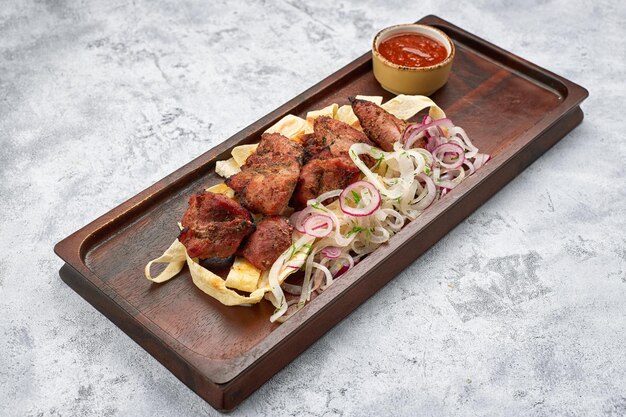 Fried pork kebab with sauce and onion