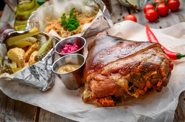 Fried pork leg with potatoes on a wooden board