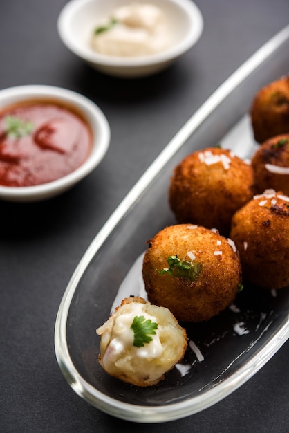 Fried potato cheese balls or croquettes with tomato ketchup. Selective focus