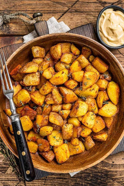 Фото Жареный картофель - закуски из традиционного испанского картофеля patatas bravas тапас. деревянный фон. вид сверху.