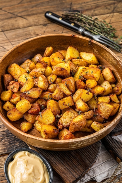 Жареный картофель - Patatas bravas традиционная испанская закуска из картофеля тапас. деревянный фон. Вид сверху.