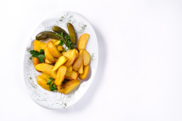 Fried potato slices on a white plate pickled with cucumber, isolated on a white background