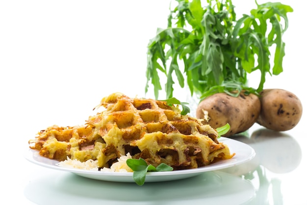 Fried potato waffles with cheese in a plate on white background