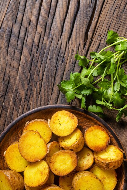 Foto spicchi di patate fritte su uno sfondo di legno scuro