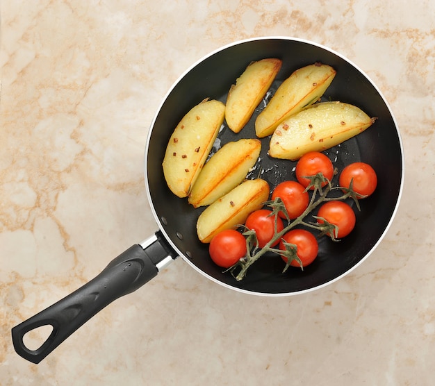 Photo fried potatoes and cherry tomatoes