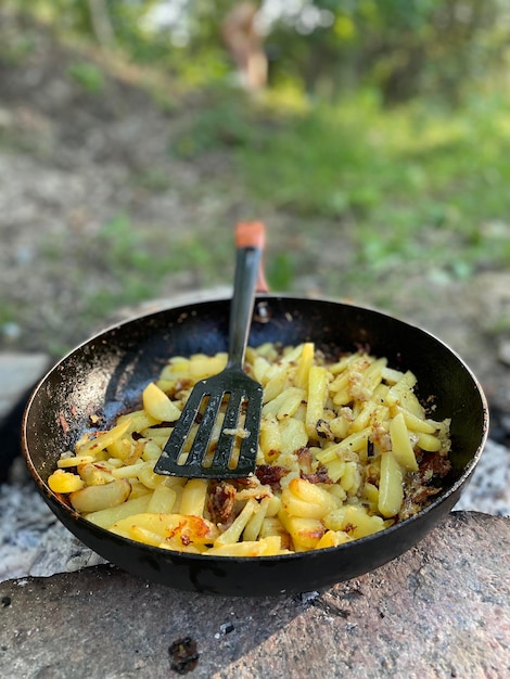 Fried potatoes in a frying pan on the nature