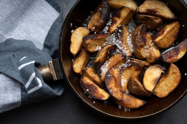 Fried potatoes in a skillet, junk food, fast food