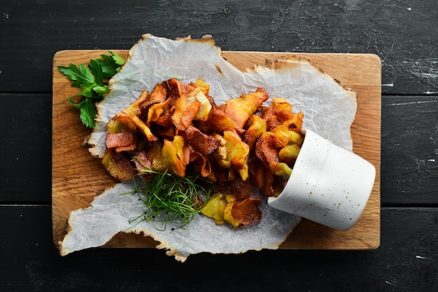 Fried potatoes with bacon Homemade potato chips Top view free space for your text Rustic style