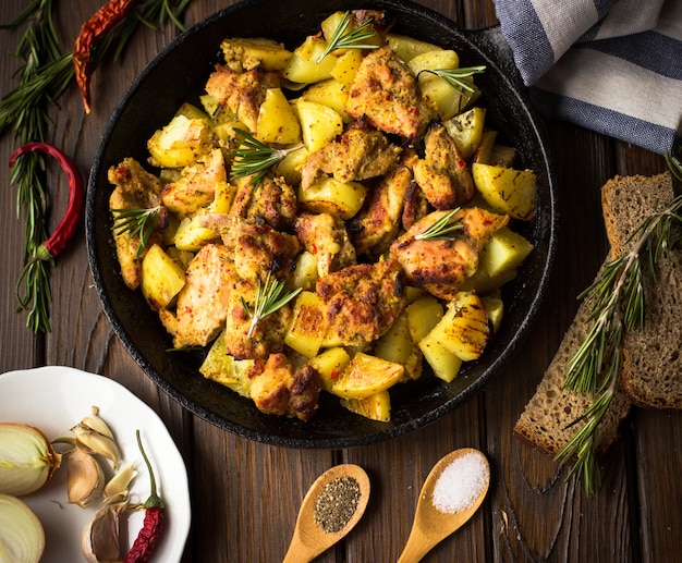 Fried potatoes with chicken in a cast-iron frying pan