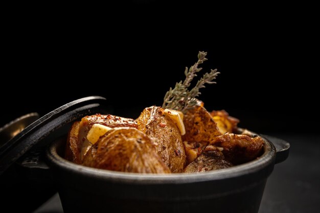 Fried potatoes with garlic and spices in a small castiron pot