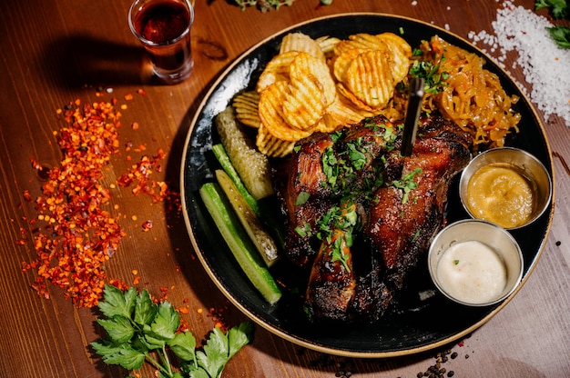 Photo fried potatoes with meat on a plate on a wooden table.top view