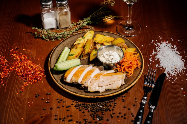 Fried potatoes with meat on a plate on a wooden table.Top view