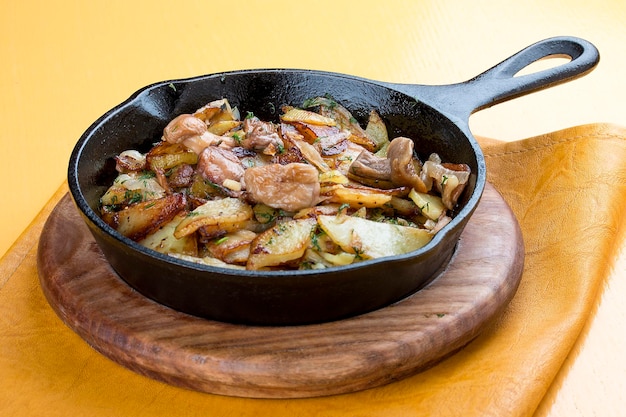 Fried potatoes with mushrooms in a cast iron pan