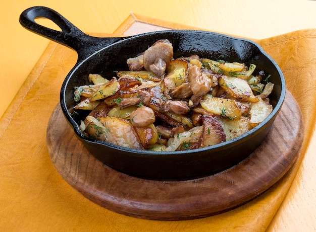 Fried potatoes with mushrooms in a cast iron pan