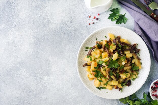 Fried potatoes with mushrooms and fresh herbs. Copy space