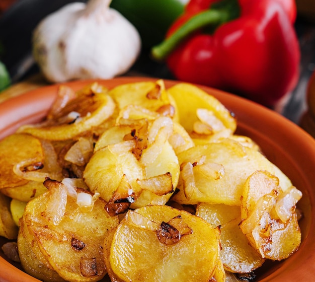 Fried potatoes with onions on wooden tray