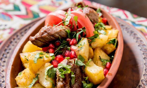 Fried potatoes with pieces of meat in a clay pot. European cuisine.