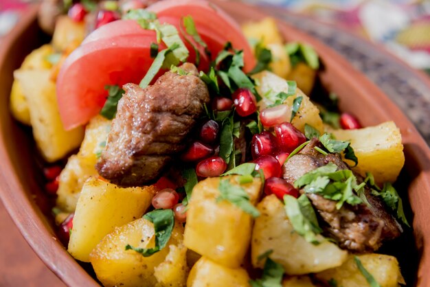 Fried potatoes with pieces of meat in a clay pot. European cuisine.