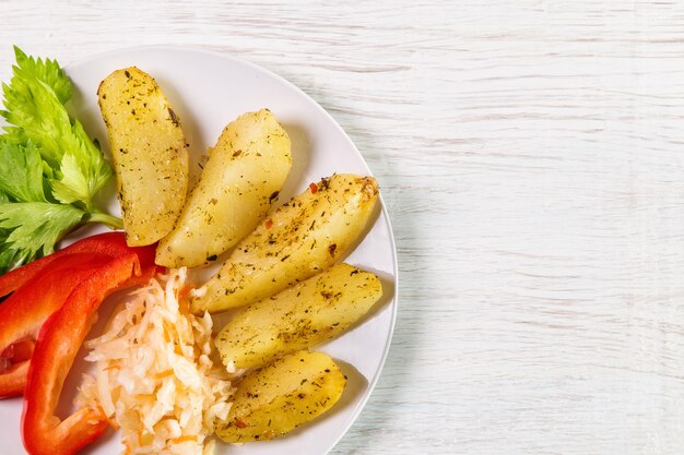 Photo fried potatoes with sauerkraut, sweet peppers and celery