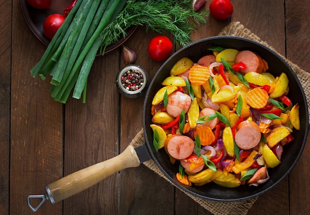 Fried potatoes with vegetables and sausages