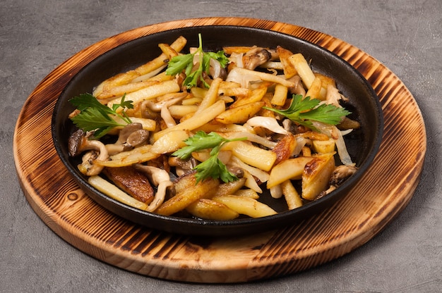 Fried potatoes with wild mushrooms in a frying pan