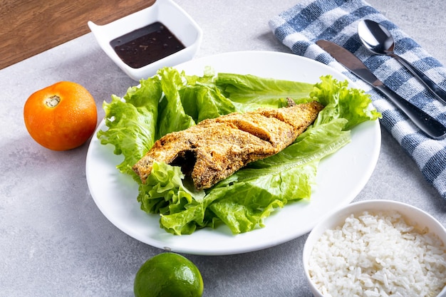 Fried quotperoaquot fish lettuce salad tomato lemon rice beans and passion fruit juice Traditional Brazilian beach food known as quotPeixe Frito Capixabaquot