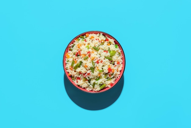 Fried rice bowl above view on a blue background