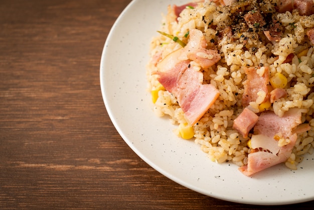 fried rice with bacon ham and black peppers on white plate