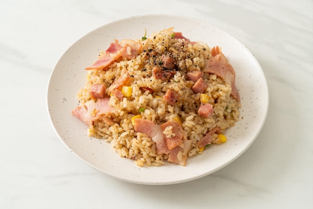 fried rice with bacon ham and black peppers on white plate