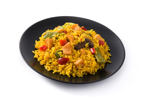 Fried rice with chicken and vegetables on black plate isolated on white