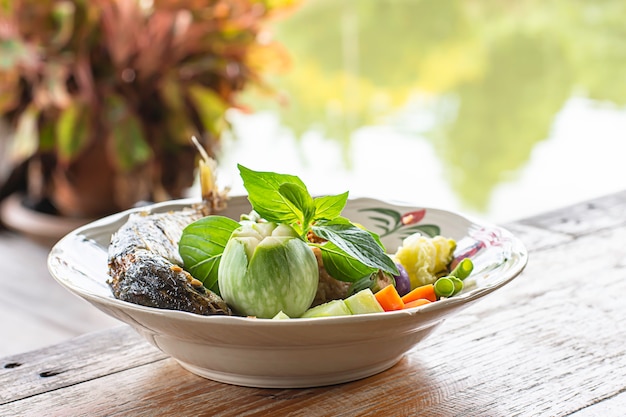 魚と野菜の白いプレートでスパイシーなチリチャーハン