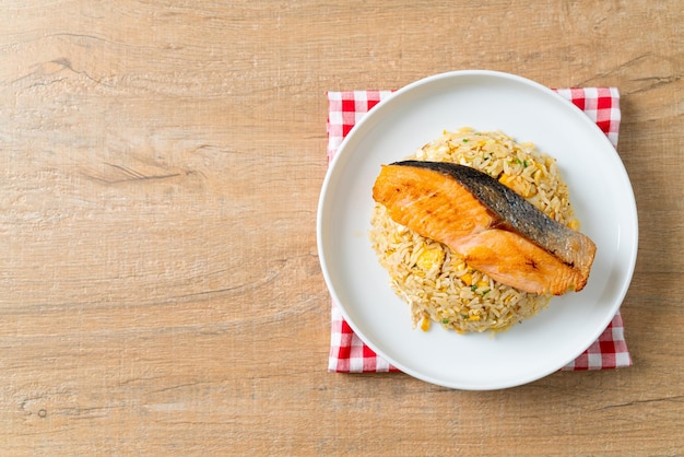 fried rice with grilled salmon fillet steak on white plate